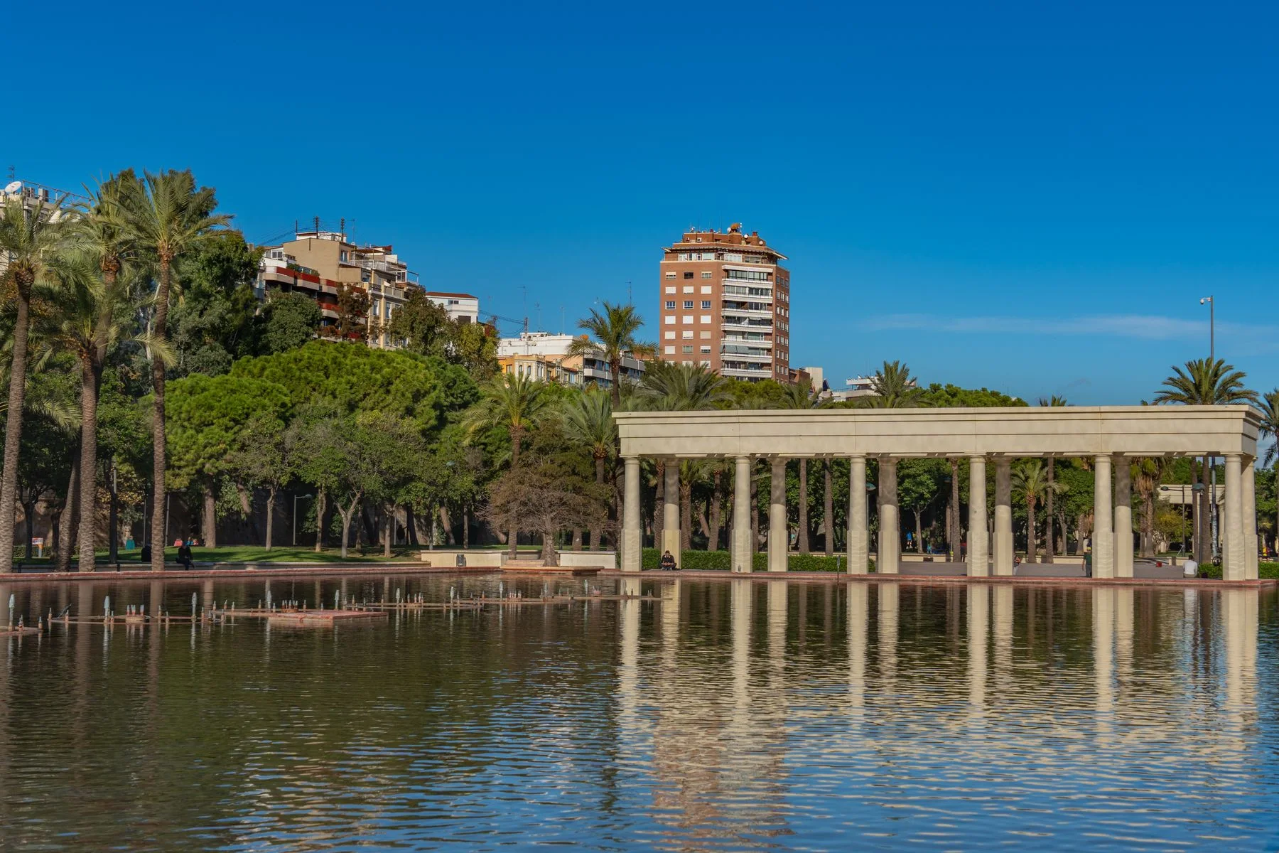 Estanque, palmeras y columnata junto al Palau de la Música en el Turia